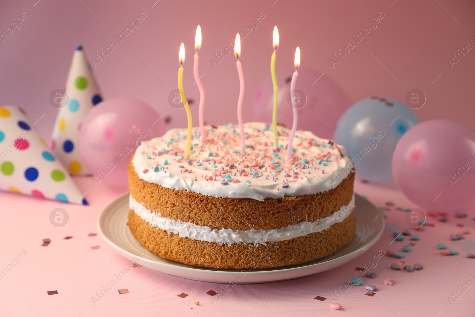 Photo of Tasty cake with colorful candles on pink background, closeup