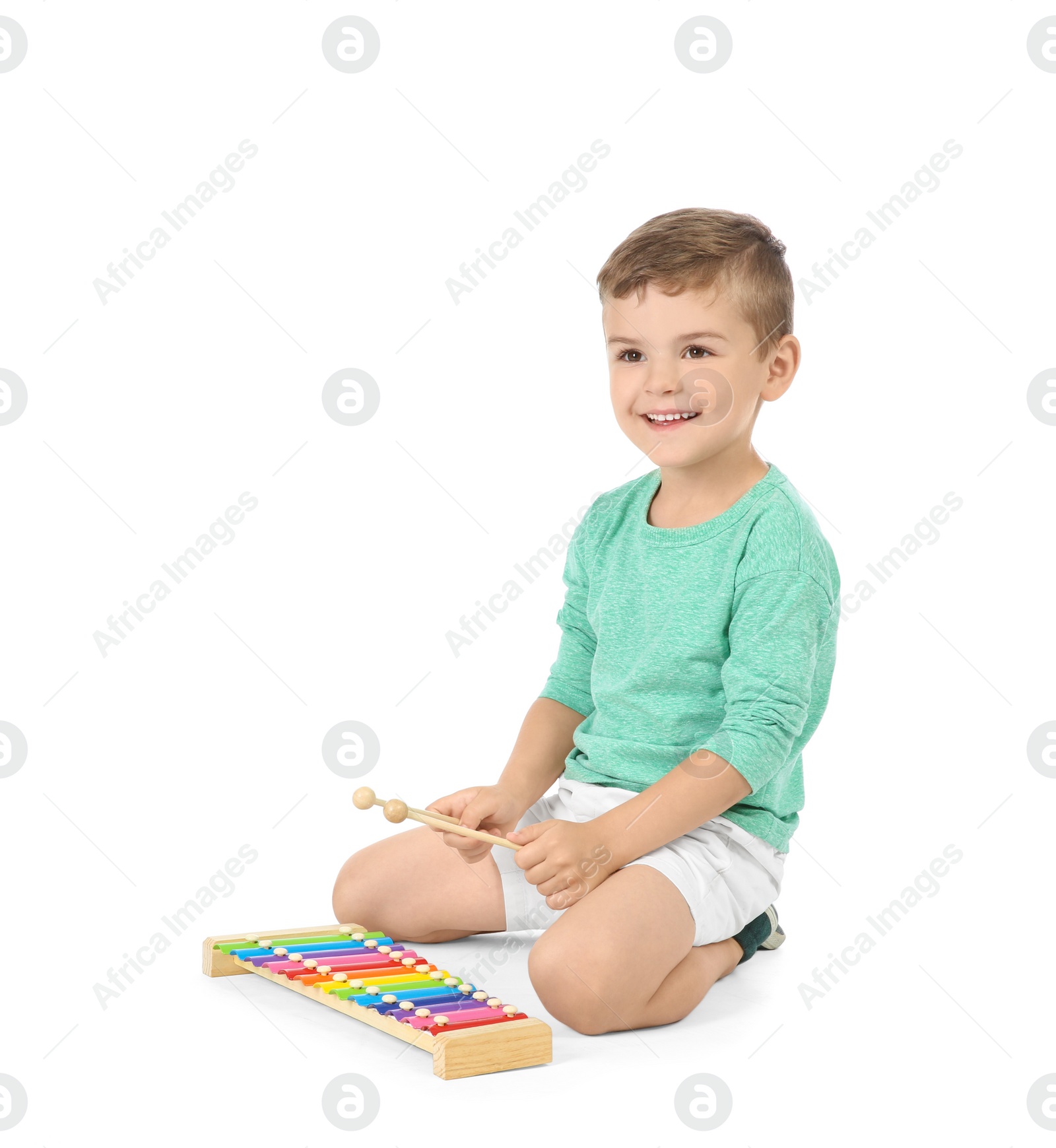 Photo of Little child playing glockenspiel against white background. Indoor entertainment