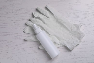 Photo of Medical gloves and antiseptic on white wooden background, flat lay