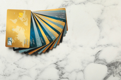 Many different credit cards on white marble background, flat lay. Space for text