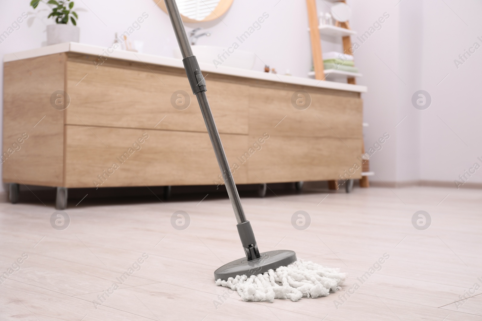 Photo of Cleaning dirty floor with mop in bathroom