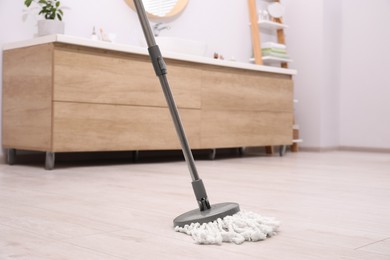 Photo of Cleaning dirty floor with mop in bathroom