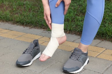 Photo of Woman with foot wrapped in medical bandage on outdoors, closeup