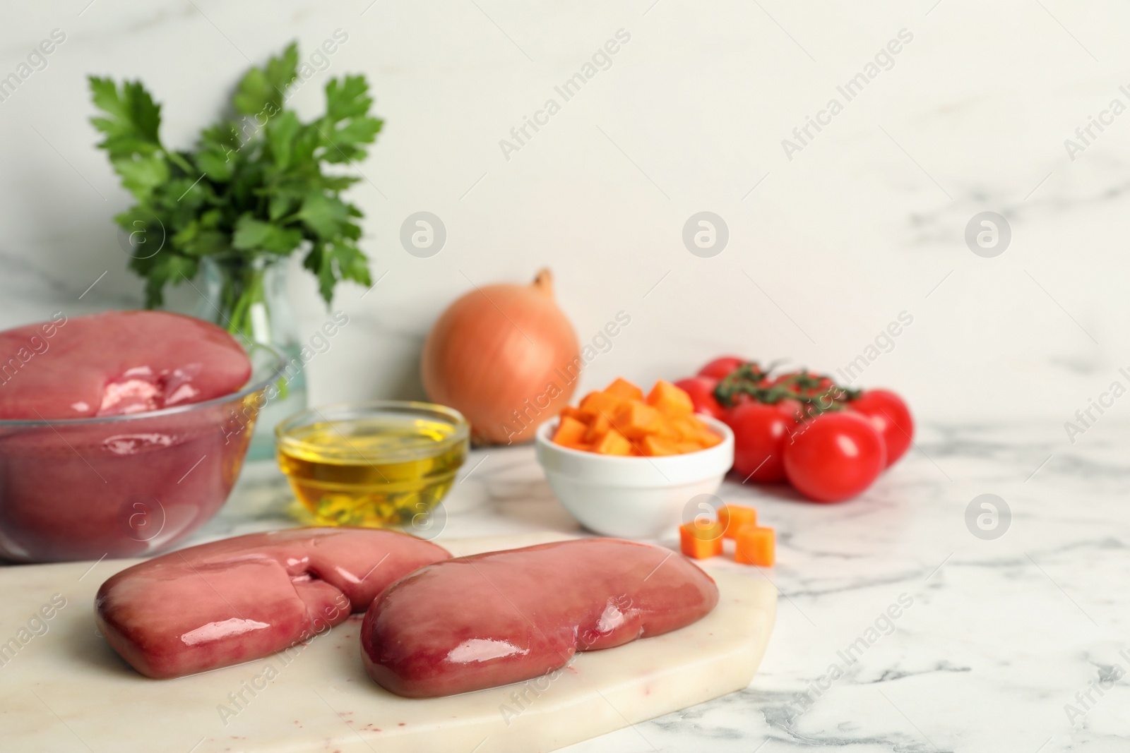 Photo of Fresh raw pork kidneys and ingredients on white marble table, space for text