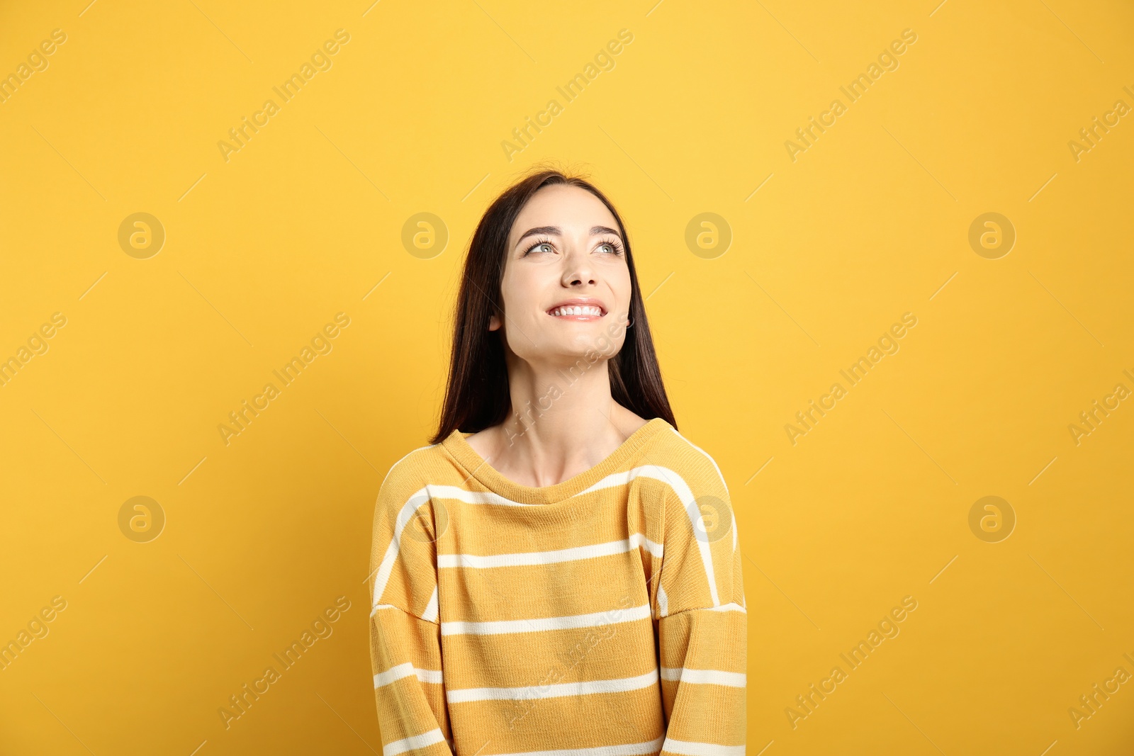 Photo of Portrait of pretty young woman with gorgeous chestnut hair and charming smile on yellow background