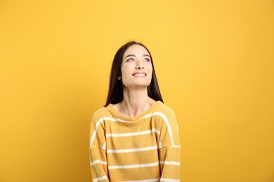 Photo of Portrait of pretty young woman with gorgeous chestnut hair and charming smile on yellow background