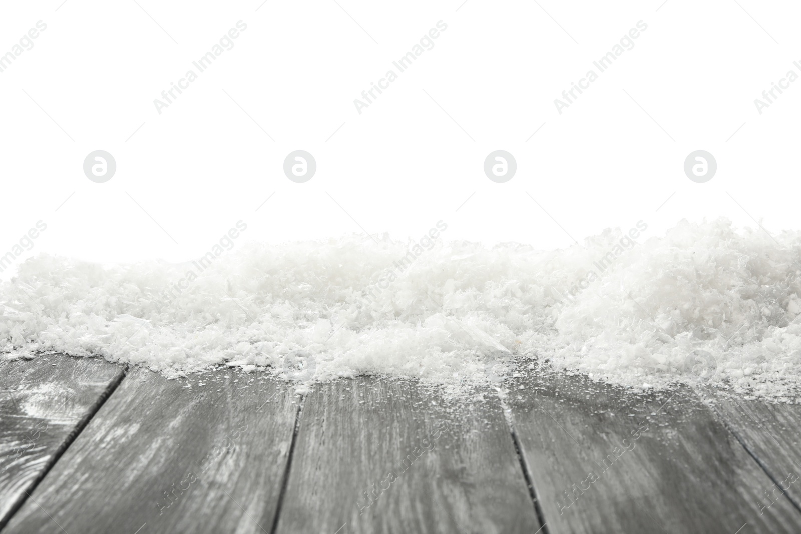 Photo of Snow on grey wooden surface against white background. Christmas season