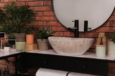 Photo of Stylish sink and beautiful green houseplants in bathroom. Interior design