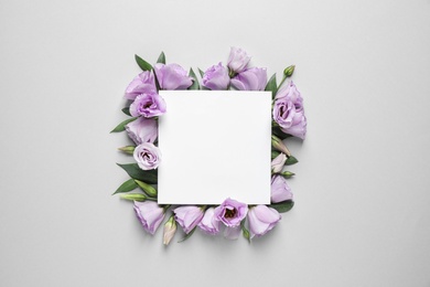 Photo of Flat lay composition with beautiful Eustoma flowers and card on grey background, space for text