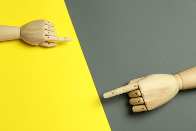 Wooden mannequin hands on color background, flat lay