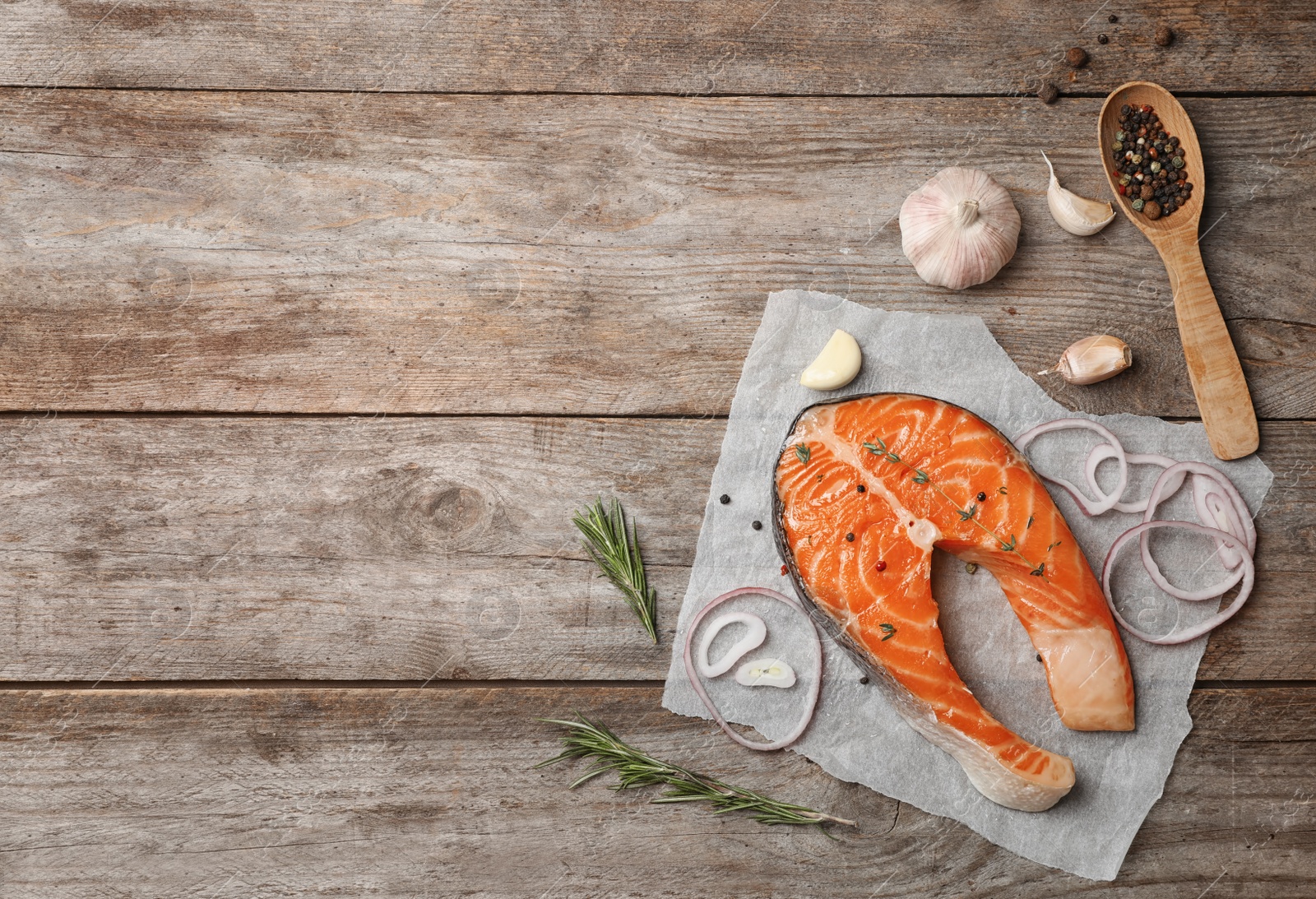 Photo of Fresh raw salmon steak with seasonings on wooden background, top view