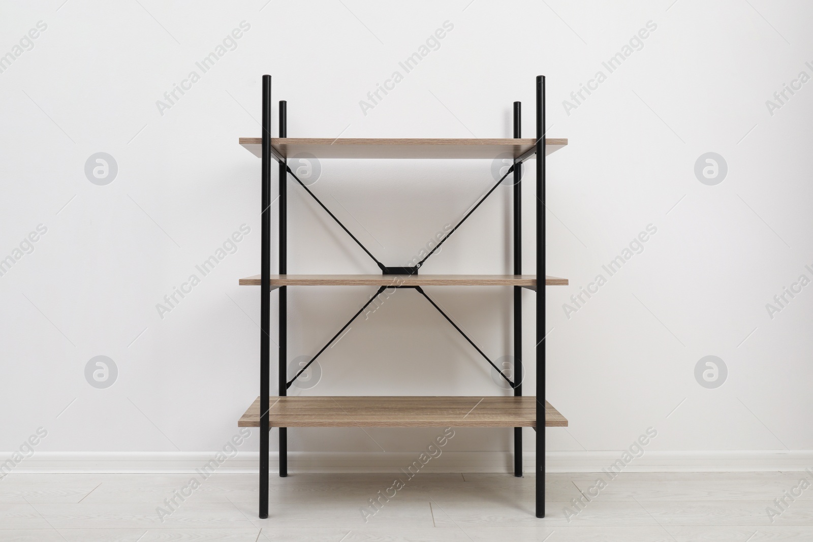 Photo of Modern wooden shelves unit at light wall