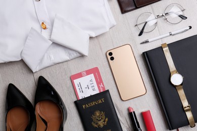 Photo of Business trip stuff on light wooden surface, flat lay