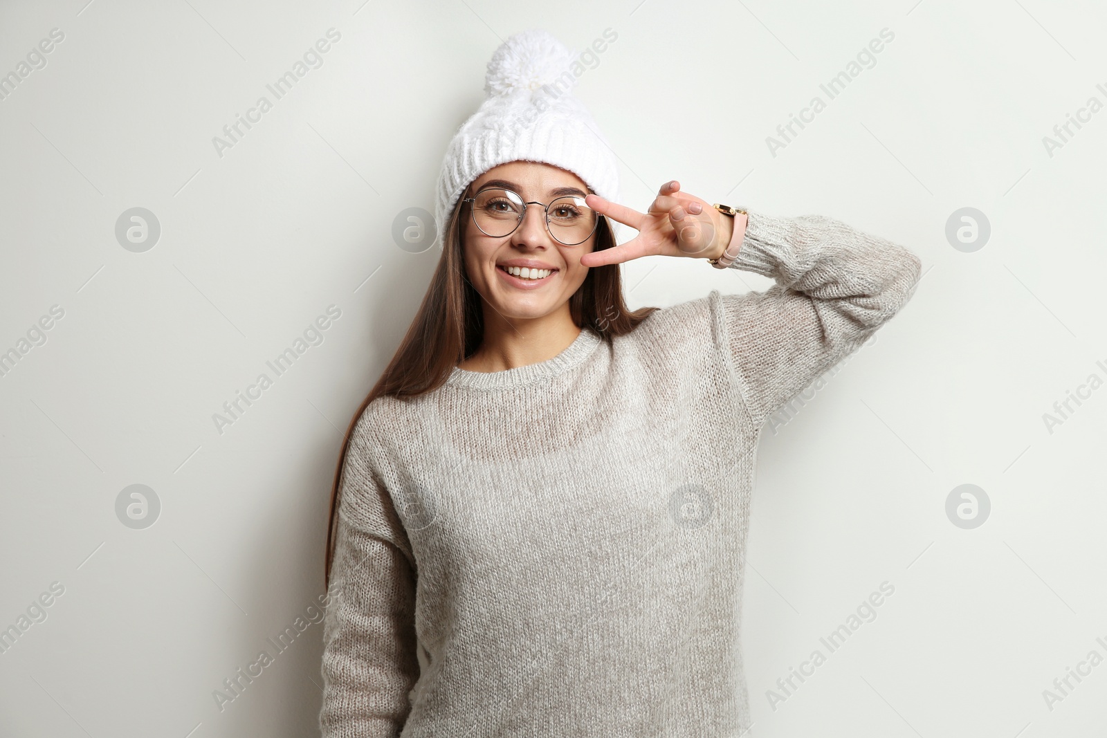 Photo of Beautiful young woman in warm sweater with hat on white background