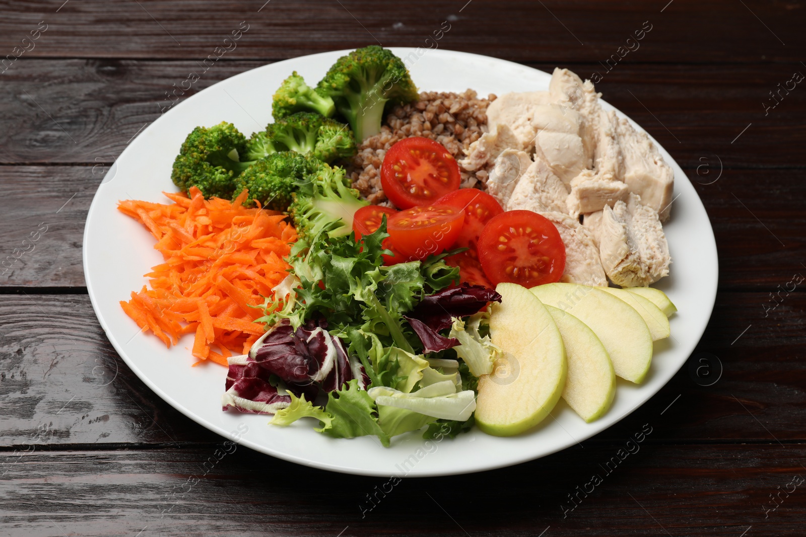 Photo of Balanced diet and healthy foods. Plate with different delicious products isolated on wooden table