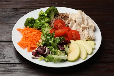 Photo of Balanced diet and healthy foods. Plate with different delicious products isolated on wooden table