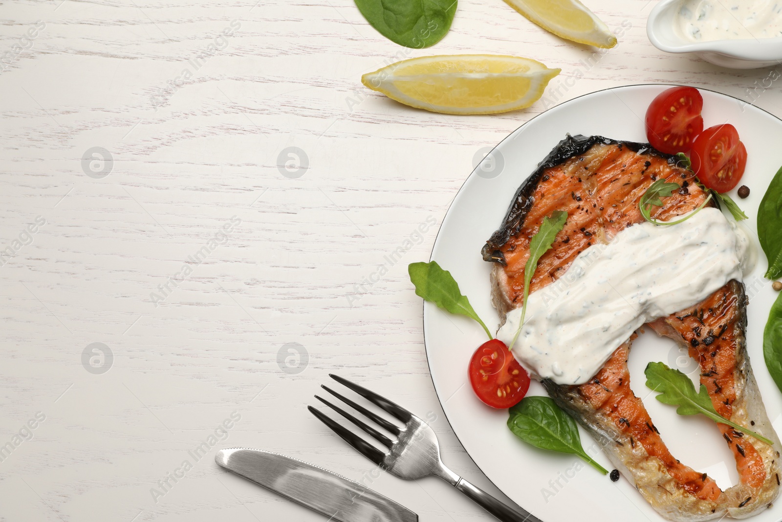 Photo of Tasty salmon steak served on white wooden table, flat lay. Space for text