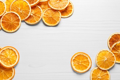 Many dry orange slices on white wooden table, flat lay. Space for text