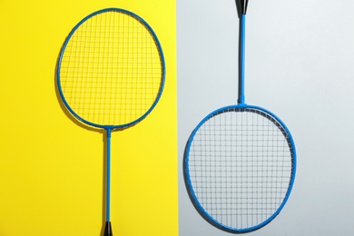 Photo of Badminton rackets on color background, flat lay