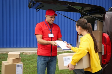 Courier receiving receipt signature from customer outdoors
