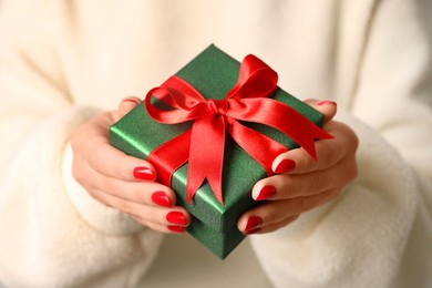 Christmas present. Woman holding gift box, closeup