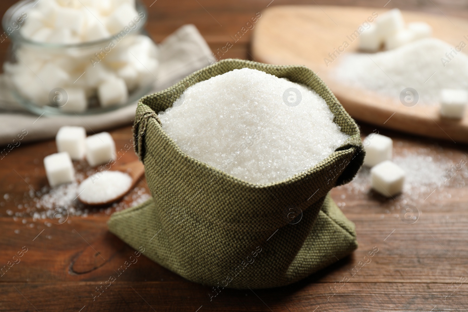 Photo of Granulated sugar in sack on wooden table