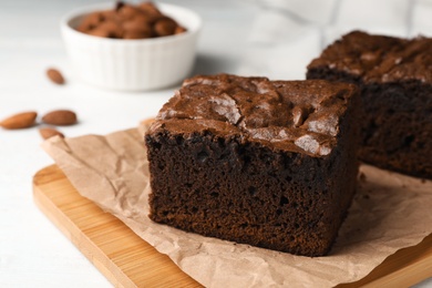 Photo of Wooden board with fresh brownies on table, space for text. Delicious chocolate pie