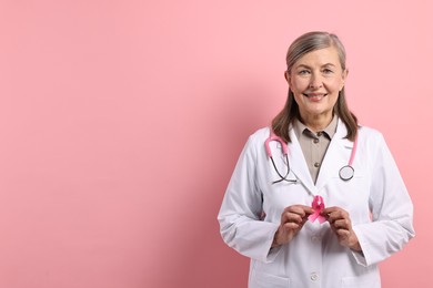 Photo of Mammologist with pink ribbon on color background, space for text. Breast cancer awareness
