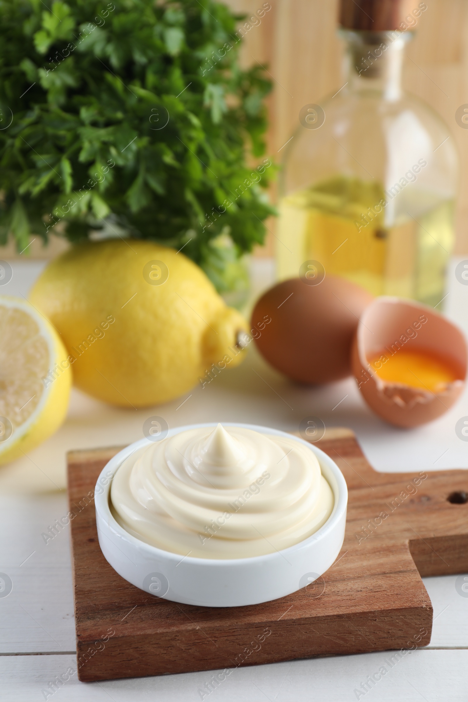 Photo of Fresh mayonnaise sauce in bowl on white wooden table