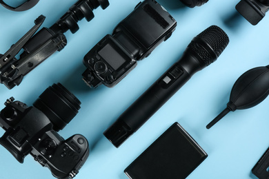 Flat lay composition with camera and video production equipment on light blue background