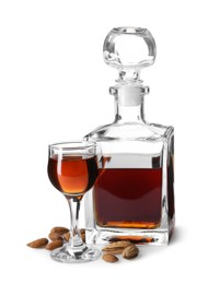 Photo of Bottle with tasty amaretto, liqueur glass and almonds isolated on white