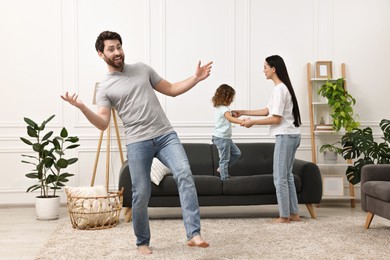 Happy family dancing and having fun in living room