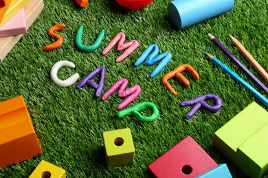 Photo of Composition with phrase SUMMER CAMP made of modelling clay on green grass