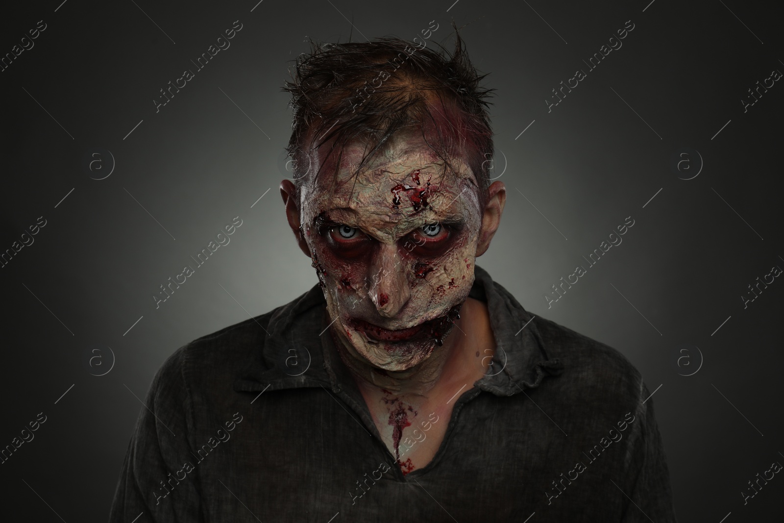 Photo of Scary zombie on dark background. Halloween monster