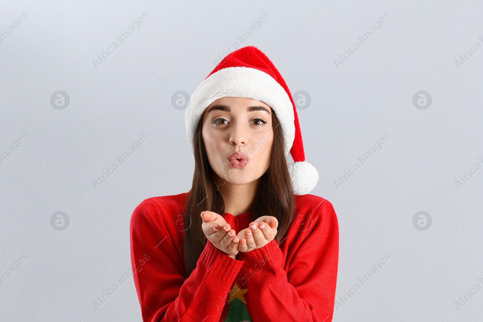 Photo of Beautiful woman wearing Santa Claus hat on light grey background