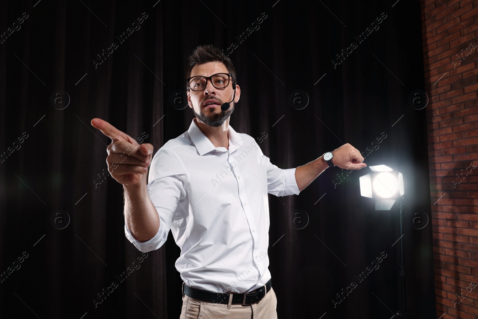 Photo of Motivational speaker with headset performing on stage