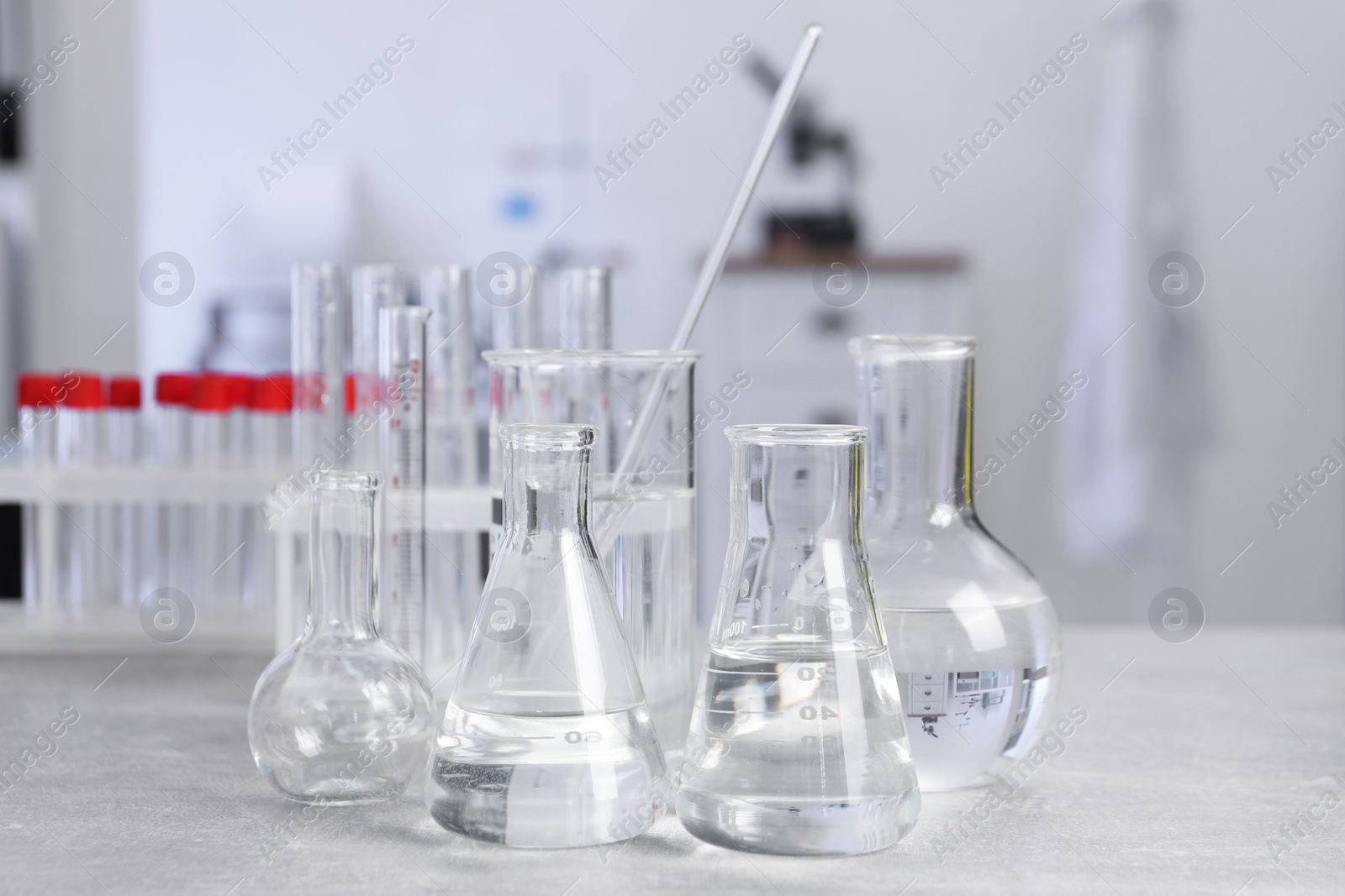 Photo of Laboratory analysis. Different glassware on light grey table indoors