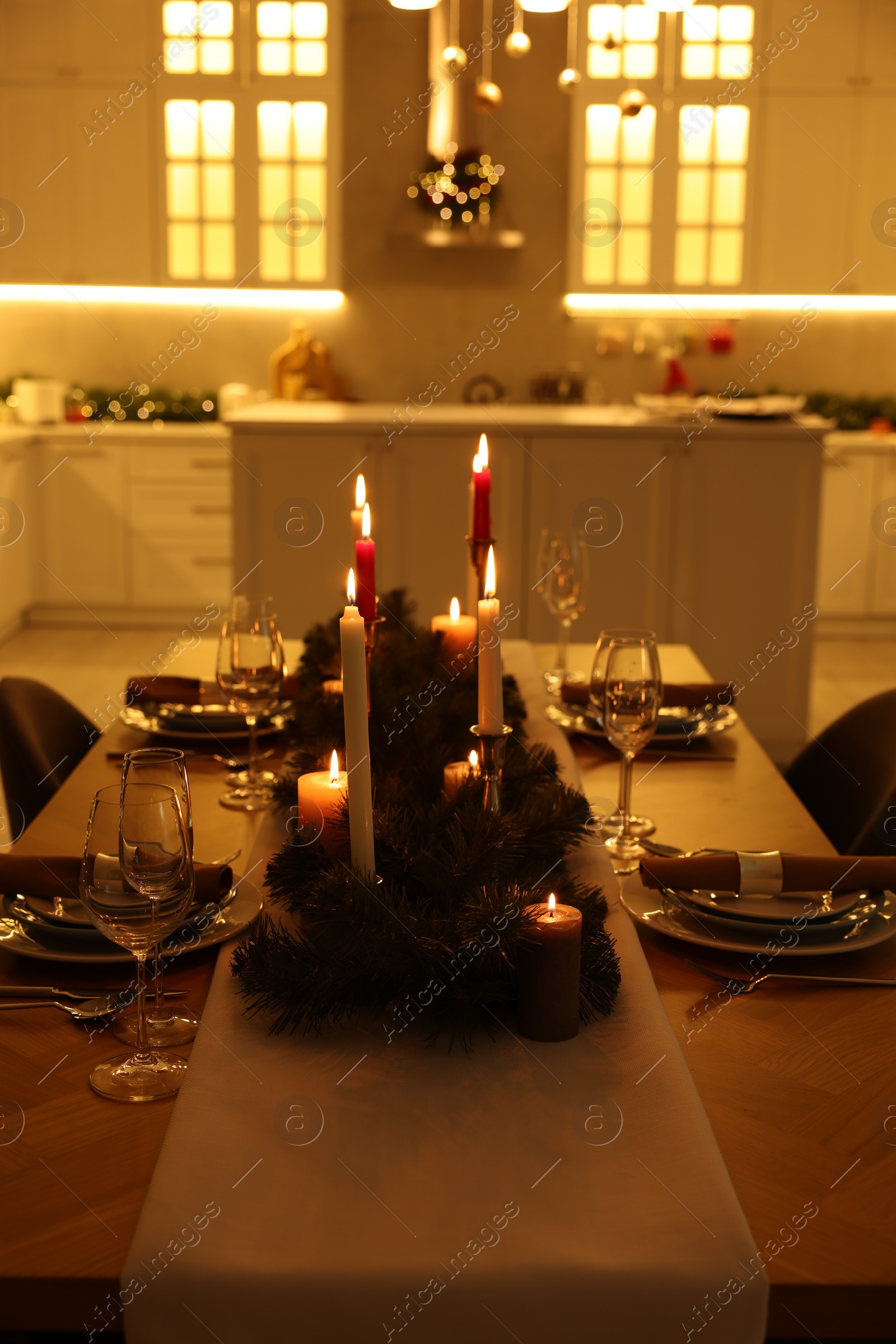 Photo of Festive table setting and beautiful Christmas decor in kitchen. Interior design