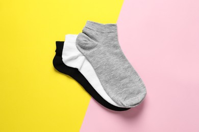 Photo of Different socks on colorful background, flat lay