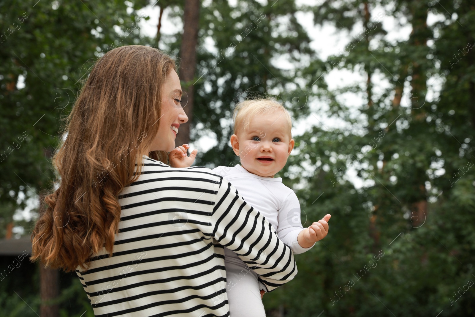 Photo of Mother with her cute baby spending time together outdoors. Space for text