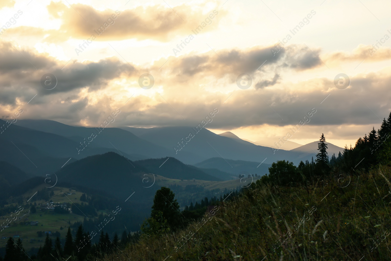 Photo of Beautiful mountains under cloudy sky at sunset. Picturesque landscape