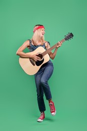 Photo of Happy hippie woman playing guitar on green background