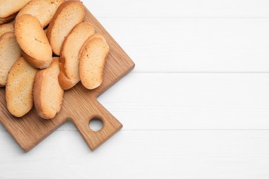 Photo of Tasty hard chuck crackers on white wooden table, top view. Space for text