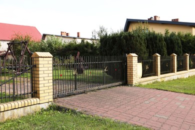 Black metal gates near private houses on street