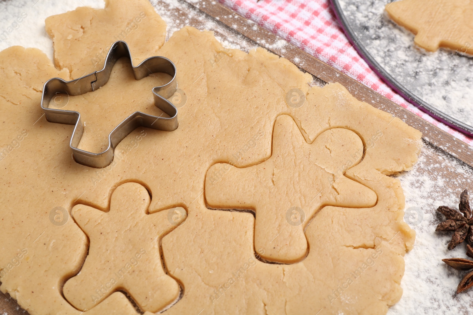 Photo of Making Christmas cookies. Raw dough and cutter on table