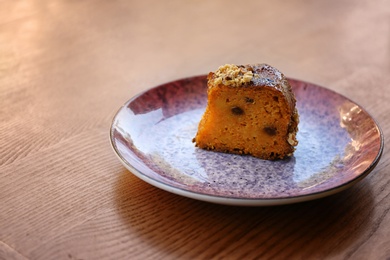 Photo of Plate with slice of carrot cake on wooden table