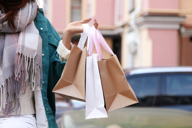 Photo of Beautiful young woman with shopping bags outdoors, closeup