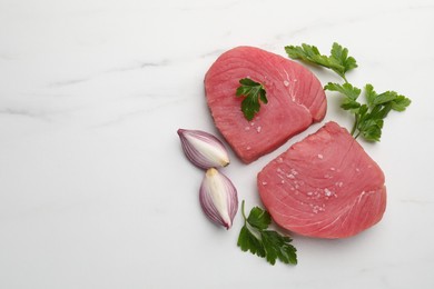 Raw tuna fillets with parsley and shallot on white marble table, flat lay. Space for text