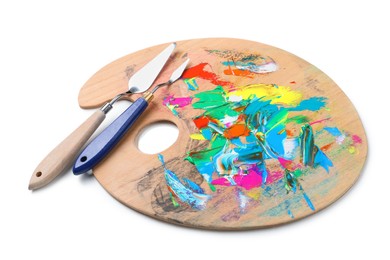 Photo of Palette with paints and spatulas on white background. Artist equipment