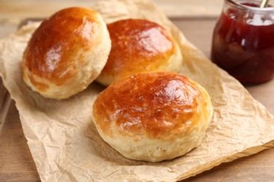 Photo of Tasty scones prepared on soda water and jam on wooden table, closeup